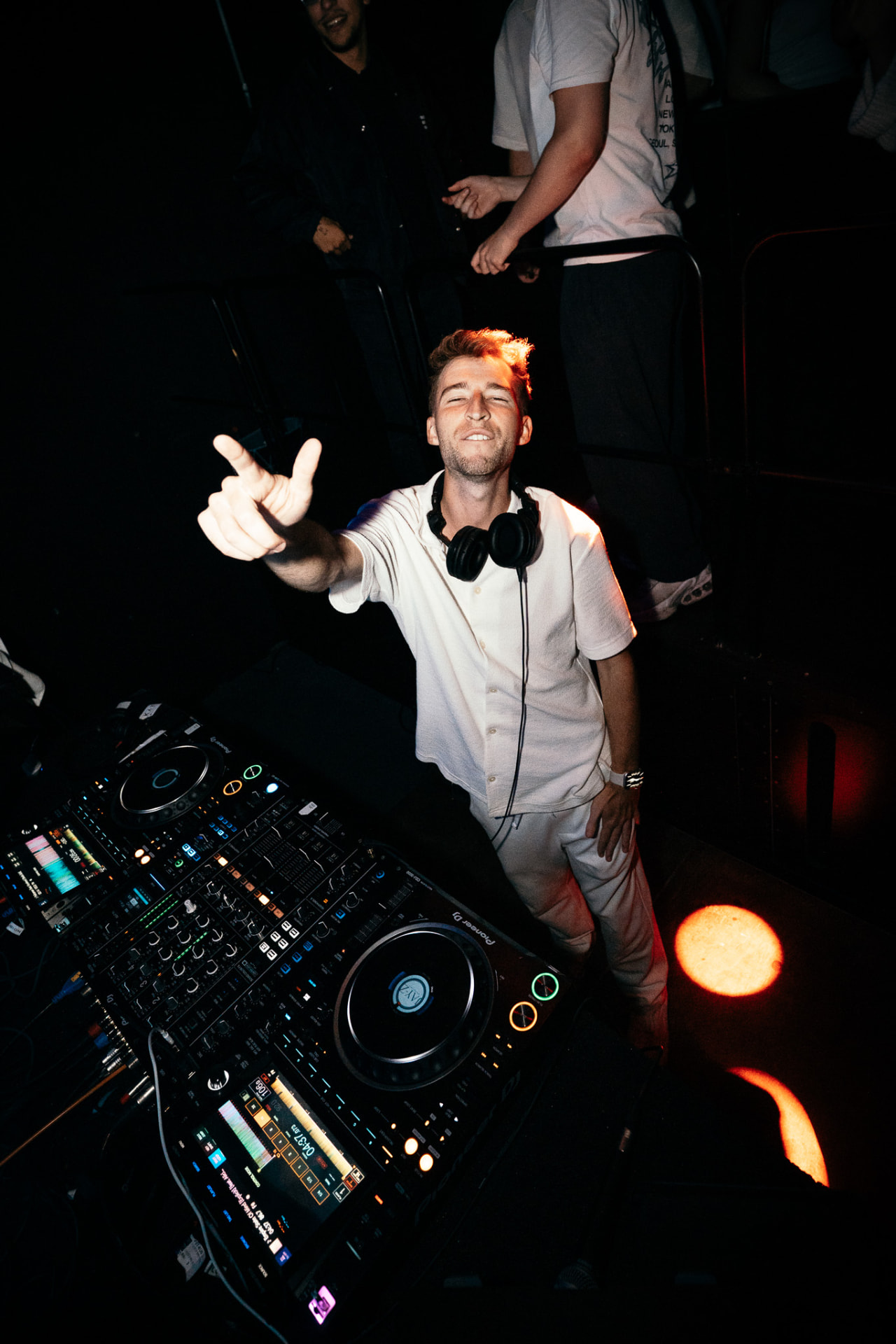 Robby Fizzy am DJ-Pult mit Kopfhörern und Peace-Zeichen